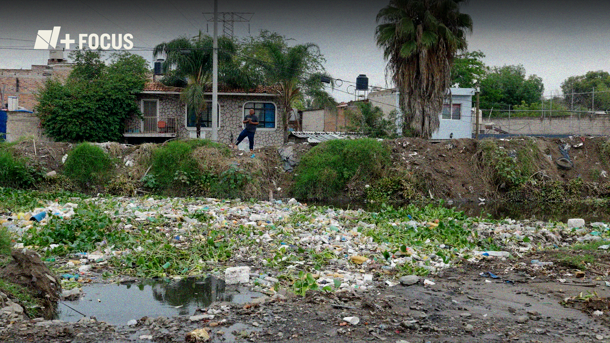 Una persona observando el canal contaminado.