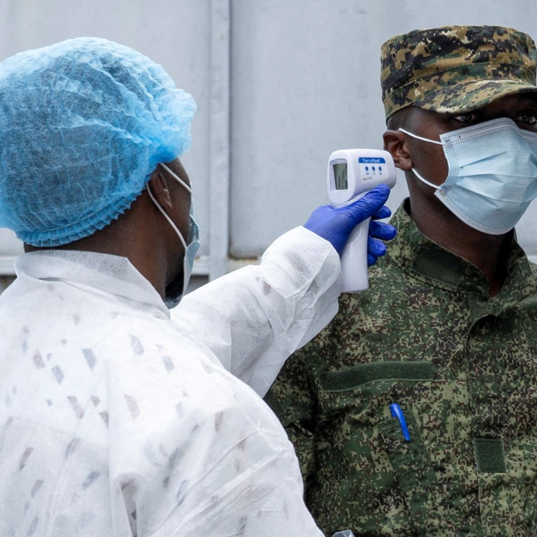 Un trabajador de salud toma la temperatura a una persona.