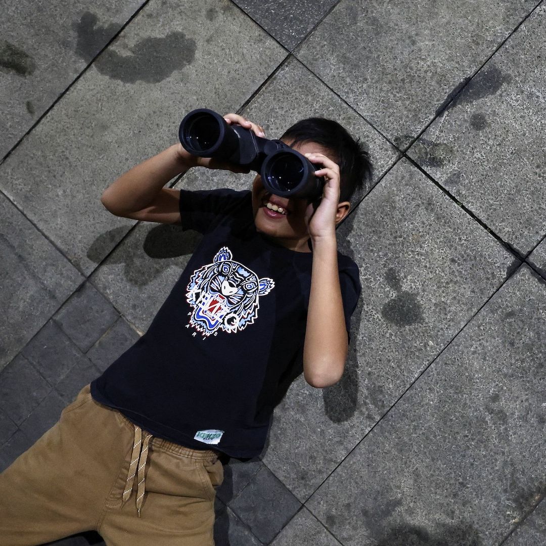 Niño observa un eclipse lunar en Jakarta