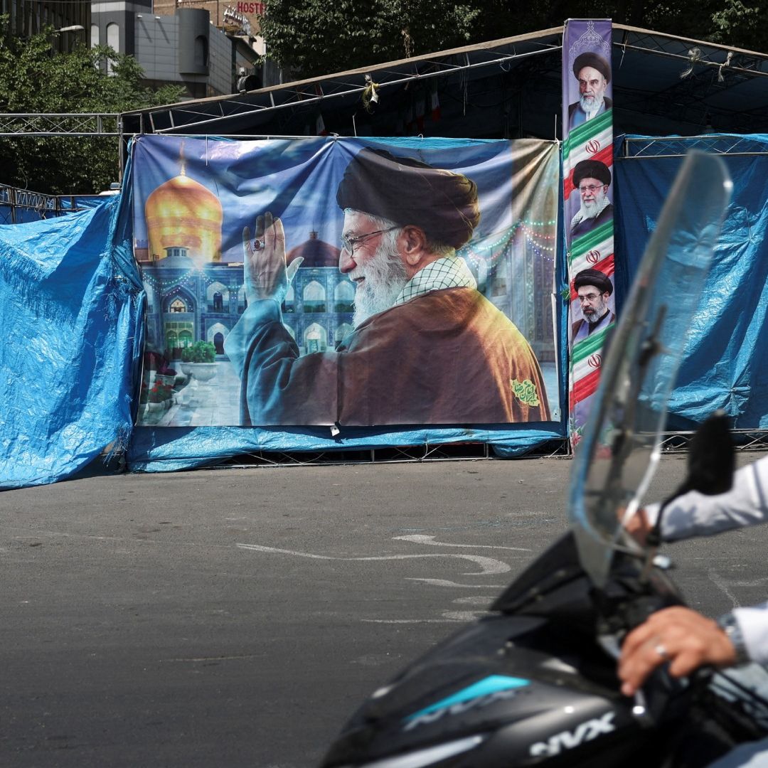 Personas pasan junto a pancarta con foto del difunto líder supremo de Irán, el ayatolá Ali Khamenei, en Teherán.