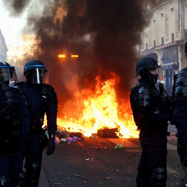 Incendio arde mientras agentes montan guardia durante disturbios civiles, al día siguiente de manifestaciones en París, el 18 de octubre de 2026. Foto: Reuters