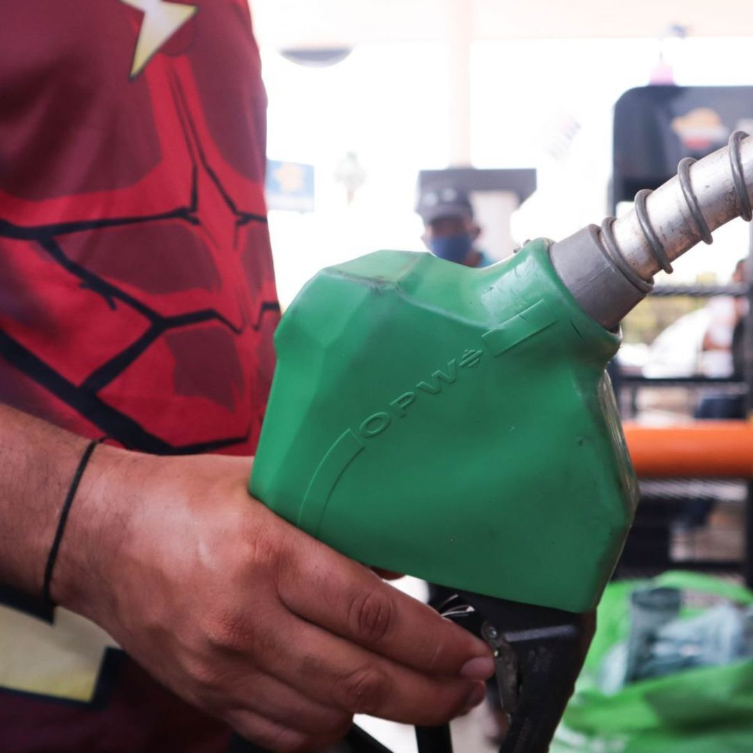 Hombre sujeta una manguera de combustible.