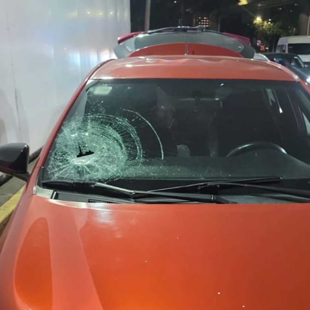 Auto dañado por piedras lanzadas desde puente en Reforma