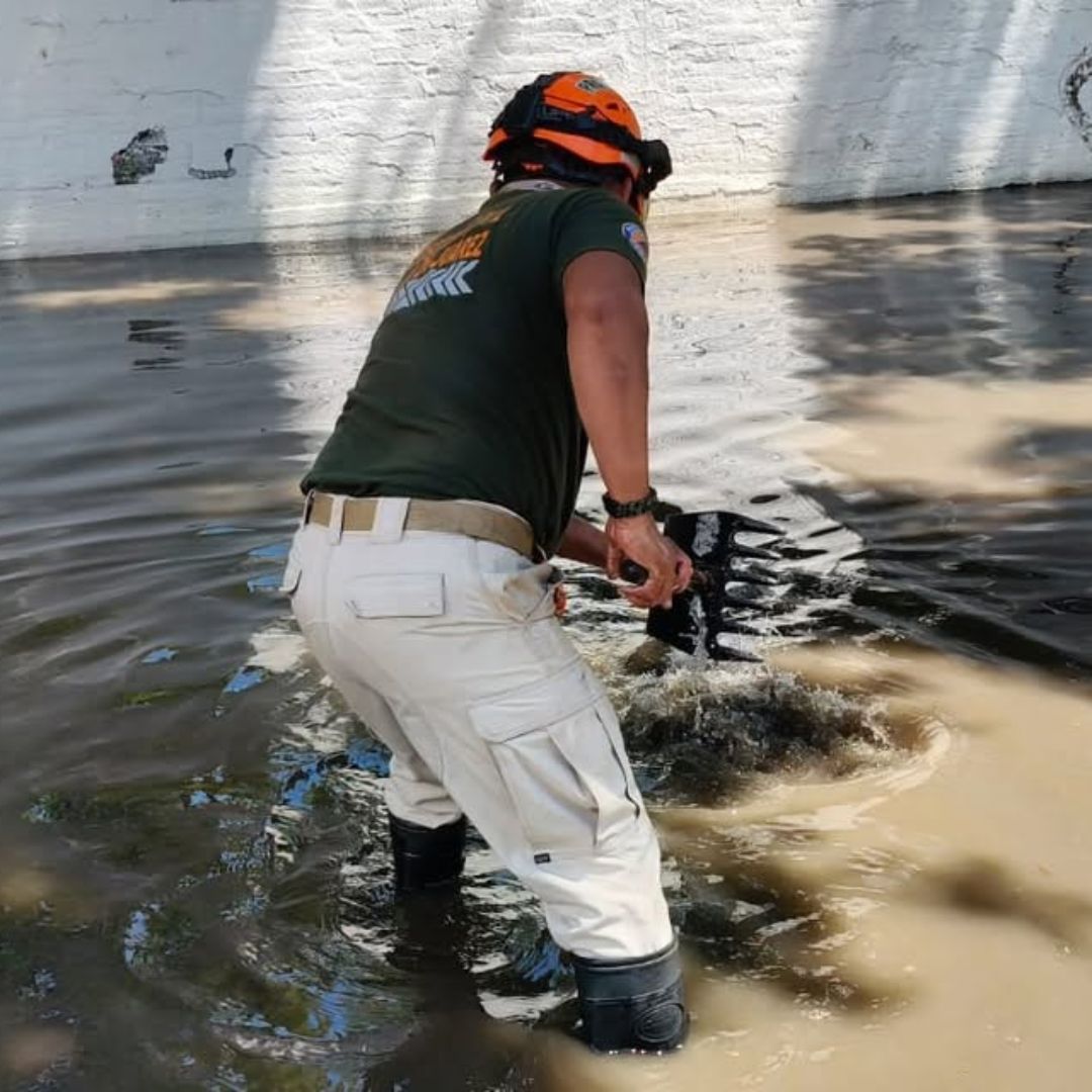 Un elemento de Protección Civil de Oaxaca intenta eliminar una anegación en la capital oaxaqueña