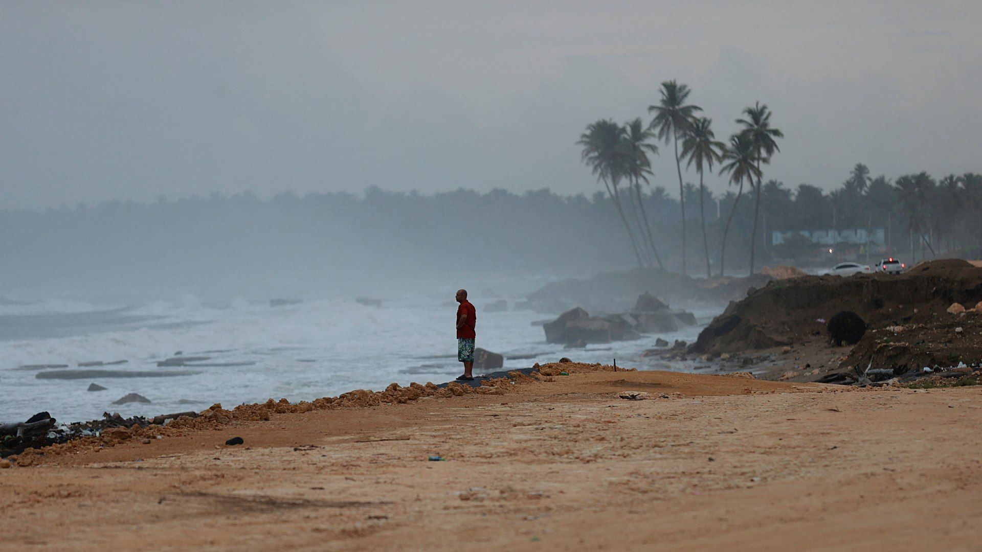 Un hombre permanece de pie en una playa de República Dominicana tras el paso del huracán Erin en agosto 2025.