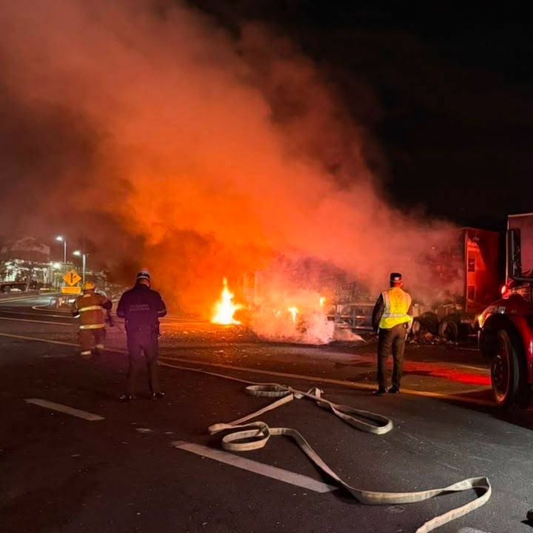 Cuerpos de emergencia combaten el incendio de la unidad de carga.