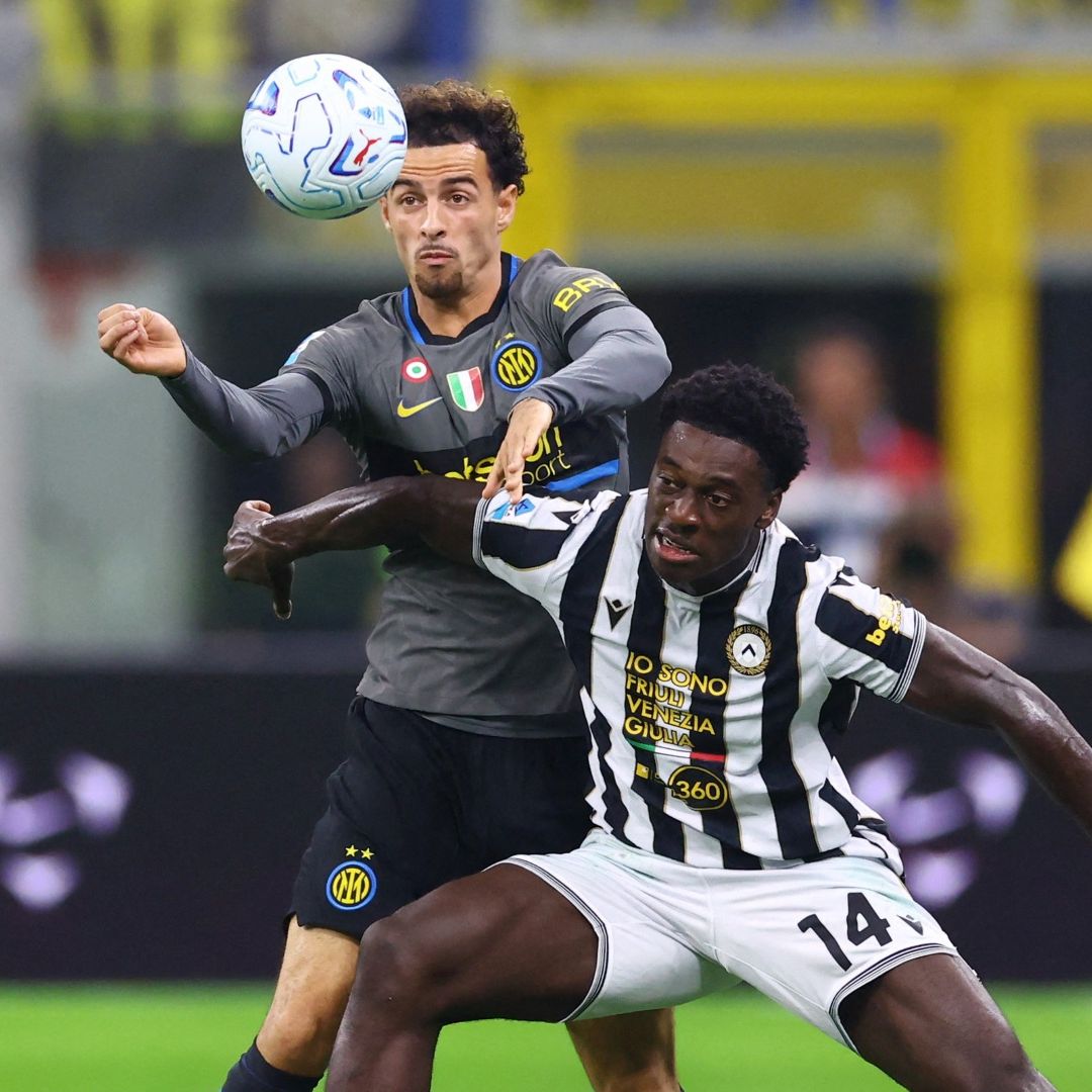 Curtis Jones, del Milán, disputa la pelota con James Abankwah, del Udinese, en el Estadio San Siro.