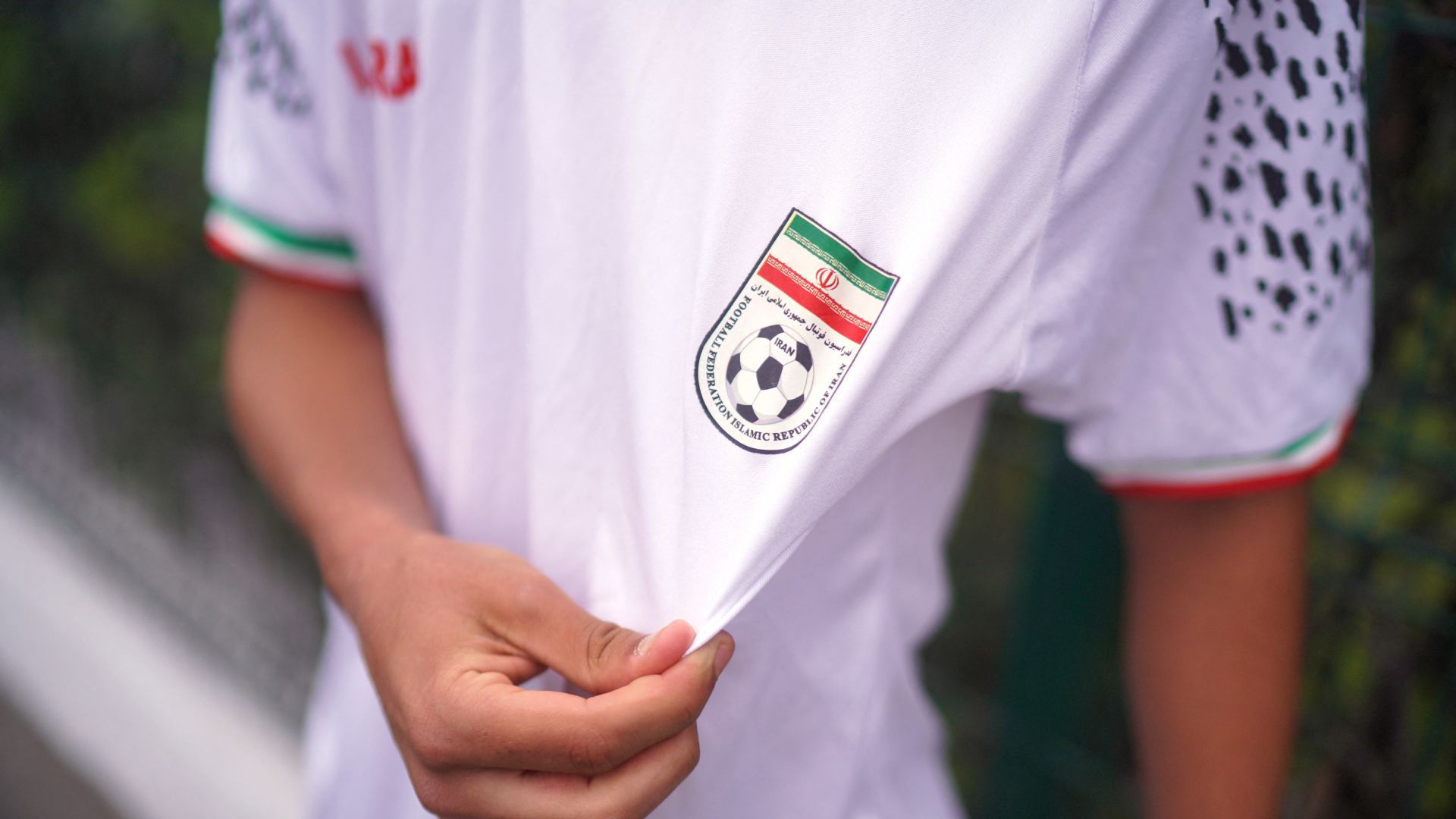 Aficionado iraní muestra la playera del conjunto persa