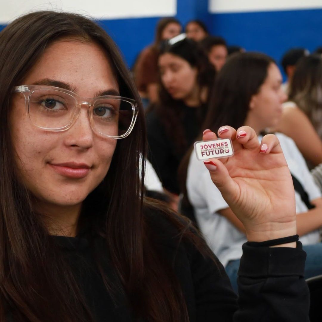 Mujer sostiene pin con logo de JCF. Cuándo abre plataforma y por cuánto tiempo recibes apoyo de 9.500 pesos.