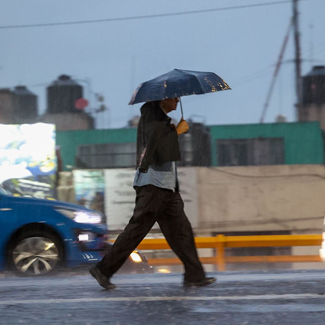 Una persona se protege con un paraguas de la fuerte lluvia en CDMX en agosto 2026. Foto: Cuartoscuro | Archivo