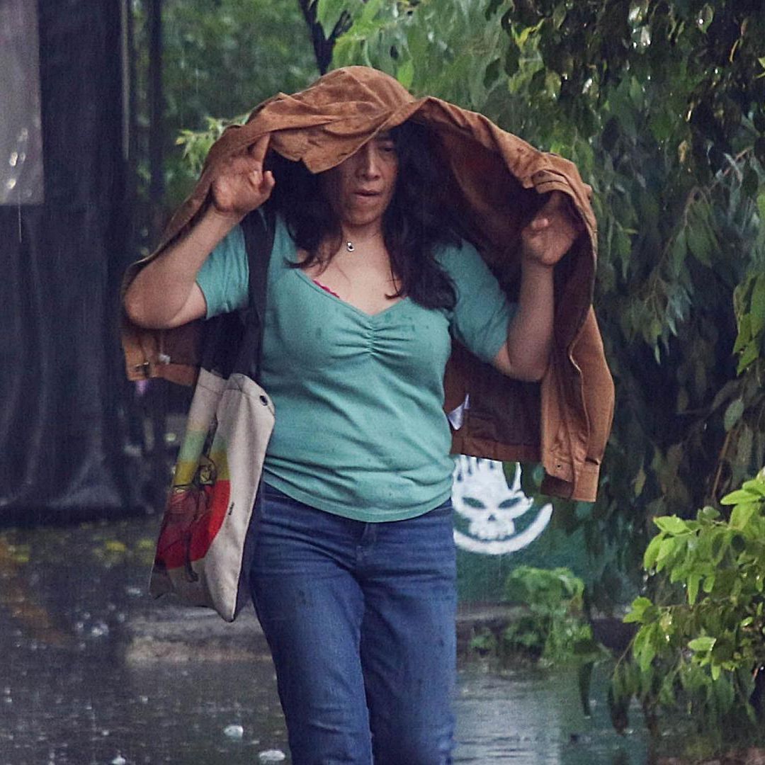 Mujer se cubre la cabeza con una chamarra ante fuerte lluvia con granizo el 22 de junio 2026 en CDMX. Foto: Cuartoscuro | Archivo