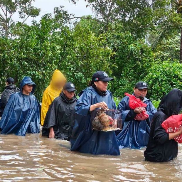 Personas caminan en medio de una inundación en Coatzacoalcos, Veracruz