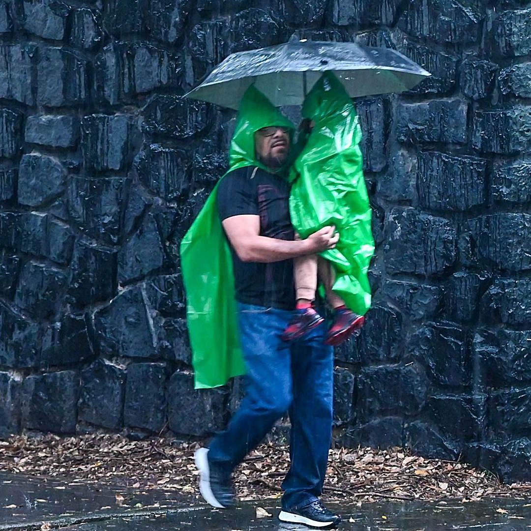 Hombre carga a su hijo y lo protege con paraguas ante lluvia intensa el 22 de agosto de 2026 en CDMX. Foto: Cuartoscuro | Archivo