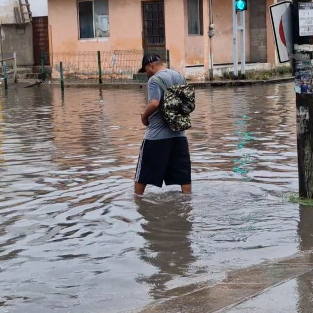Hombre caminando en inundación en Ciudad Madero, Tamaulipas