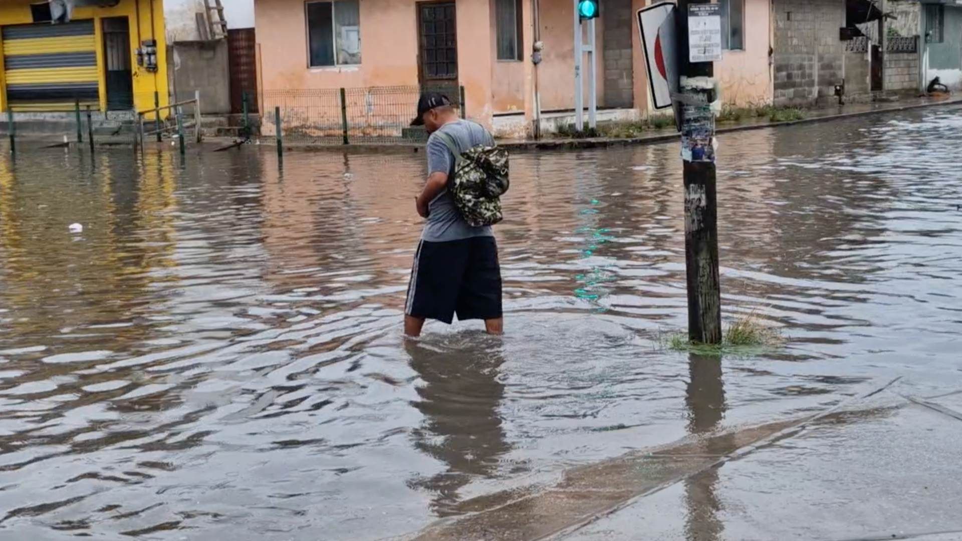 Hombre caminando en inundación en Ciudad Madero, Tamaulipas