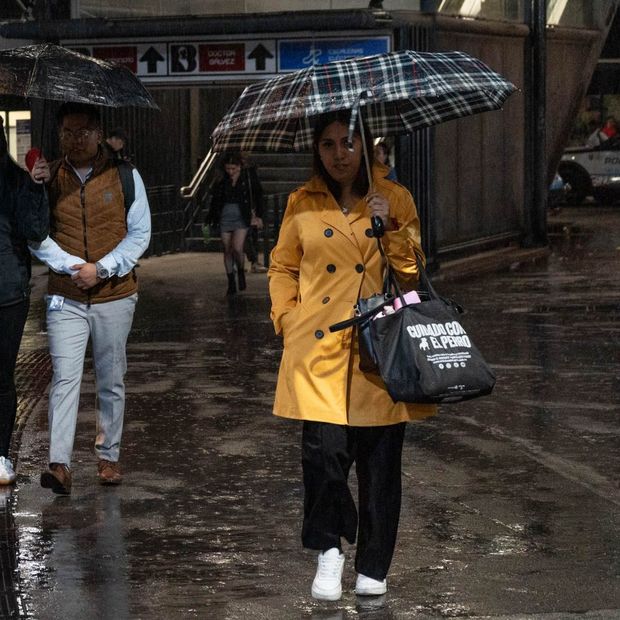Personas se cubren de la lluvia con impermeables y paraguas en la Zona Rosa, el 15 de octubre 2026. Foto: Cuartoscuro