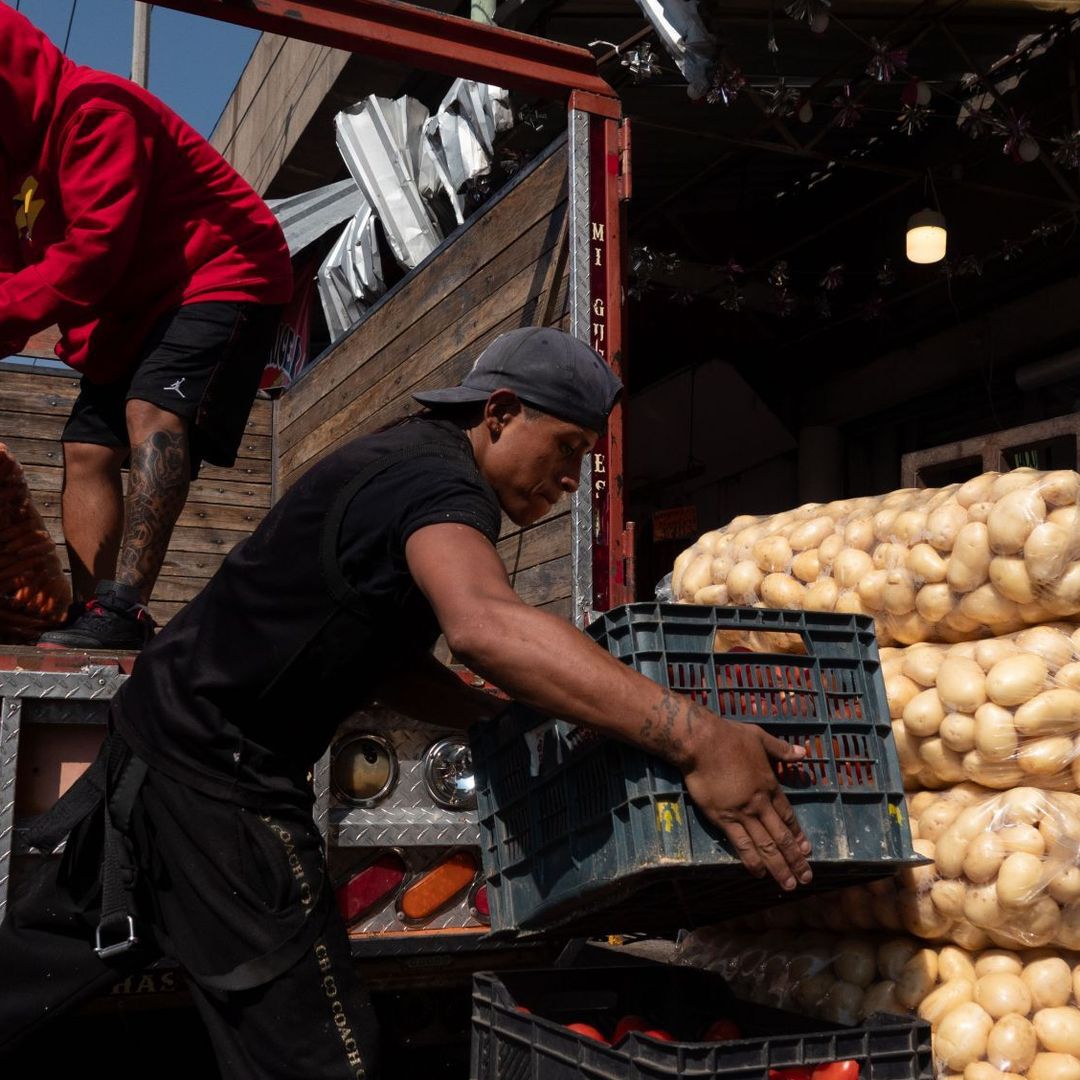 Trabajadores transportan verduras en el Mercado de la Merced.