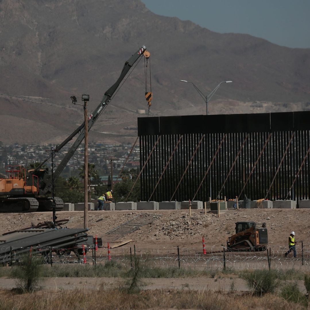 Trabajadores utilizan grúas para instalar paneles de hierro para el muro fronterizo a lo largo del Río Grande, al norte de Ciudad Juárez y frente a El Paso, Texas.
