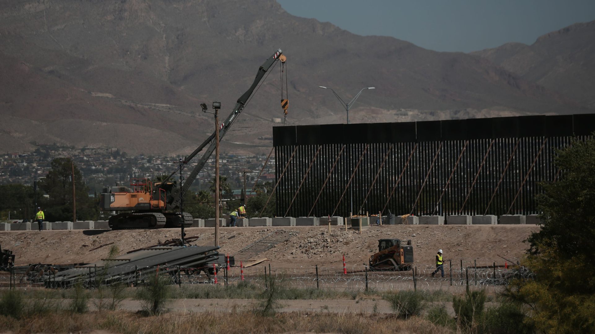 Trabajadores utilizan grúas para instalar paneles de hierro para el muro fronterizo a lo largo del Río Grande, al norte de Ciudad Juárez y frente a El Paso, Texas.