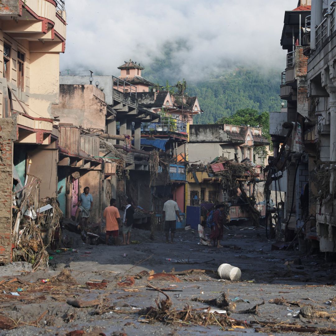 Personas caminan entre los escombros provocados por la riada en Nepal