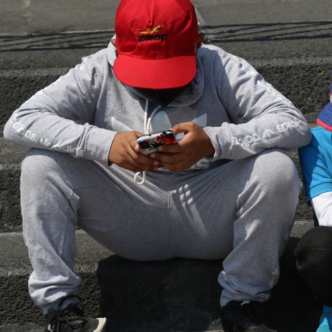 Un par de niños se entretienen con sus respectivos celulares
