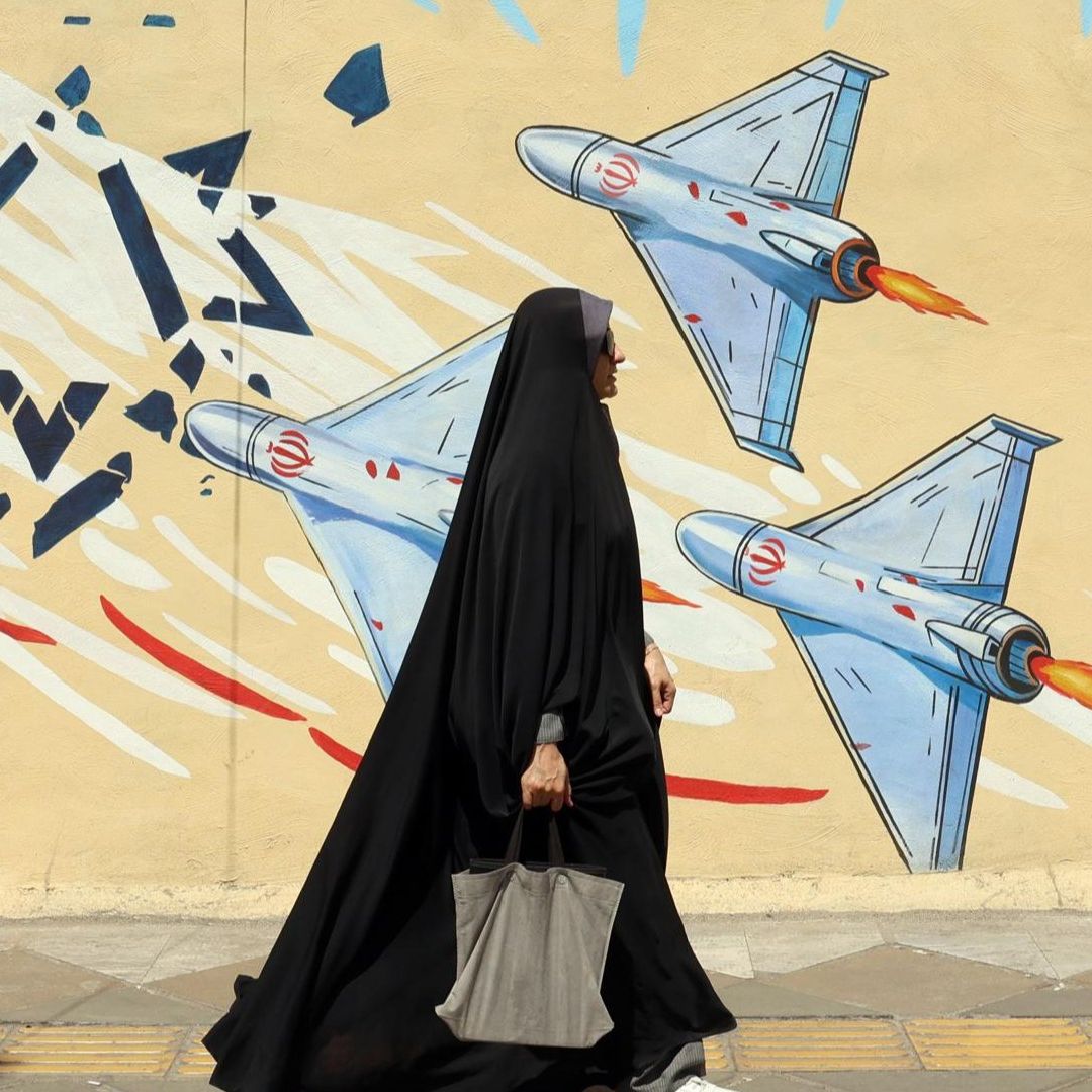 Una mujer pasa delante de un mural contra Israel, en Teherán