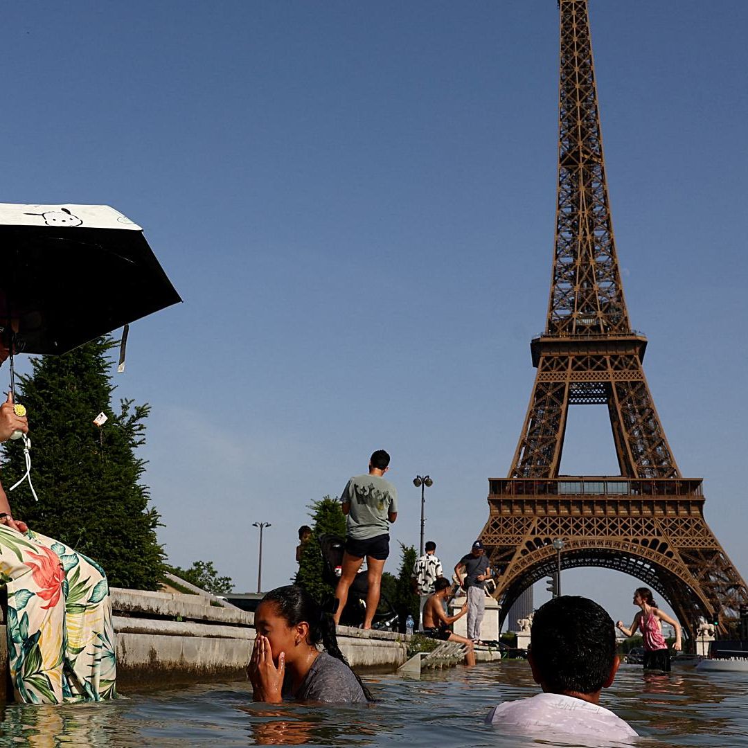 La gente se refresca en la fuente del Trocadero, frente a la Torre Eiffel, ante ola de calor en Francia, el 23 de junio de 2026. Foto: Reuters