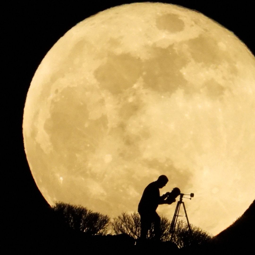 Personas con telescopio ante la Luna