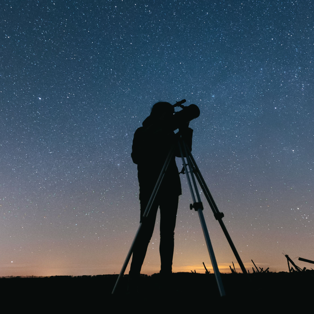 Persona observa el cielo con un telescopio