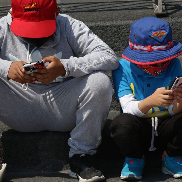 Niños se entretienen con sus respectivos celulares en CDMX. Foto: Cuartoscuro