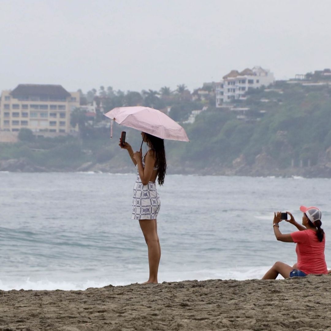 Algunas personas pasean por la Playa Zicatela en Oaxaca.