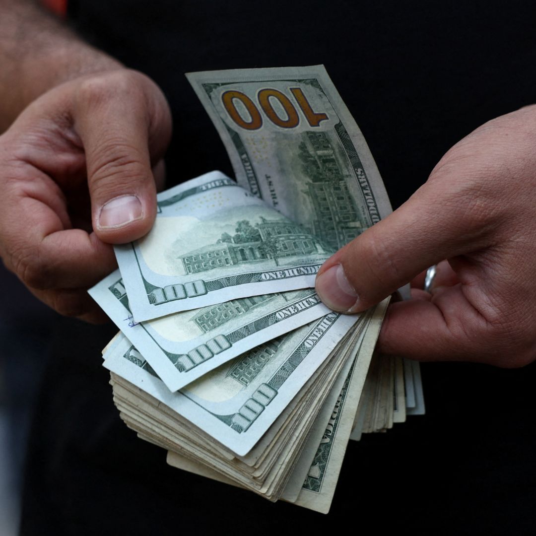 Un hombre cuenta billetes de 100 dólares