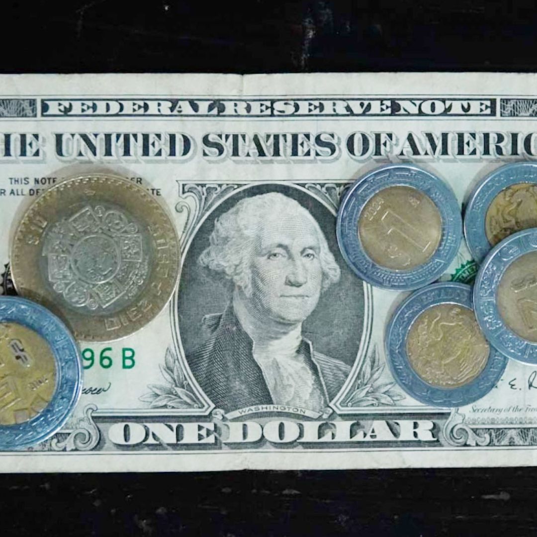 Billete de un dólar y monedas de cinco y diez pesos mexicanos