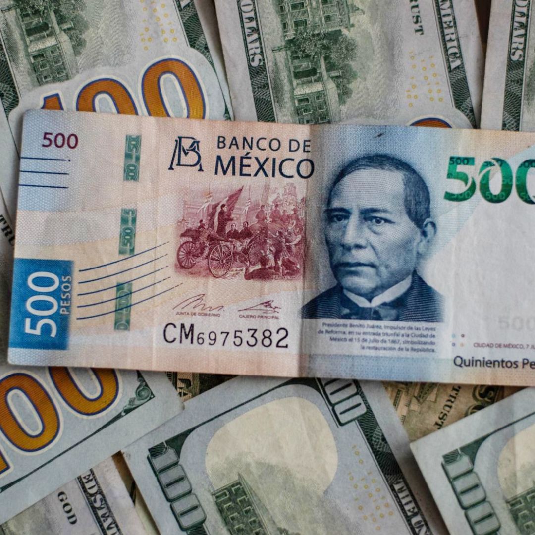 Un billete de 500 pesos sobre billetes de 100 dólares