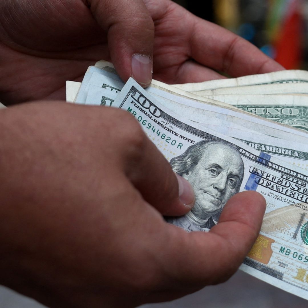Una persona cuenta billetes de 100 dólares