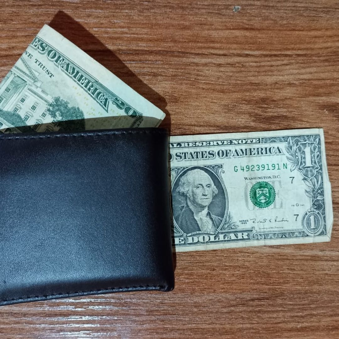 Billetes de 20 y un dólar estadounidense en una cartera