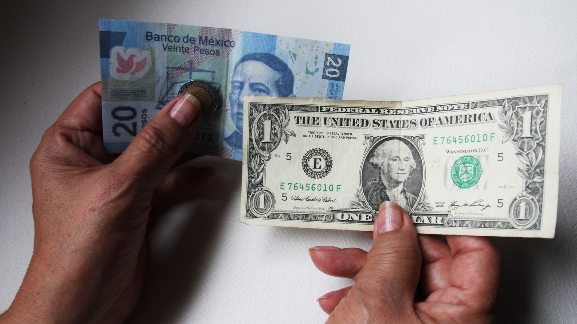 Comparación entre un billete de 20 pesos y de un dólar estadounidense