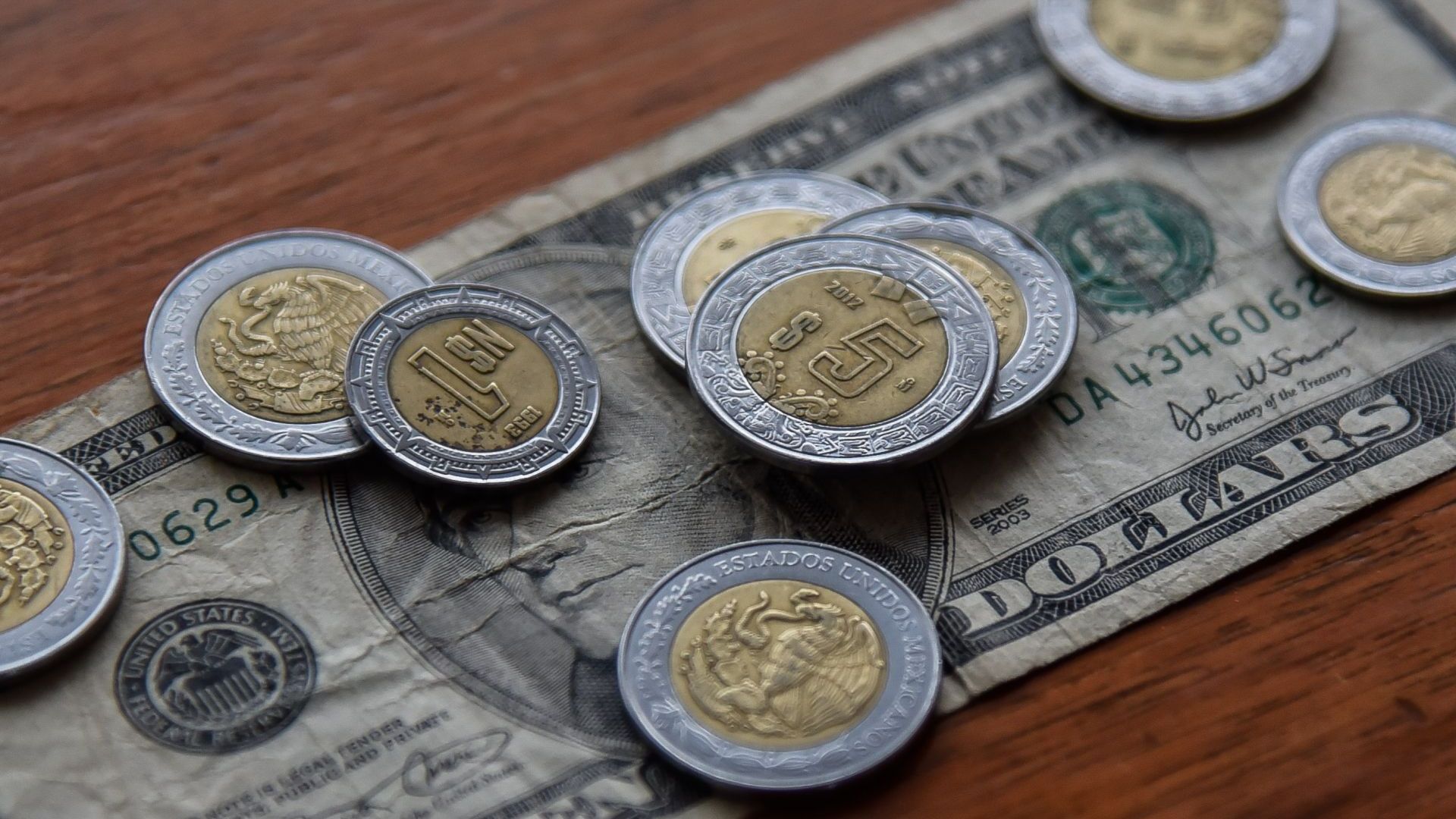 Monedas mexicanas y un billete estadounidense