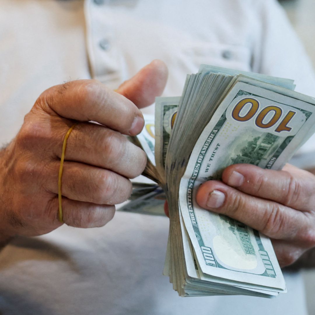 Un hombre cuenta billetes de 100 dólares