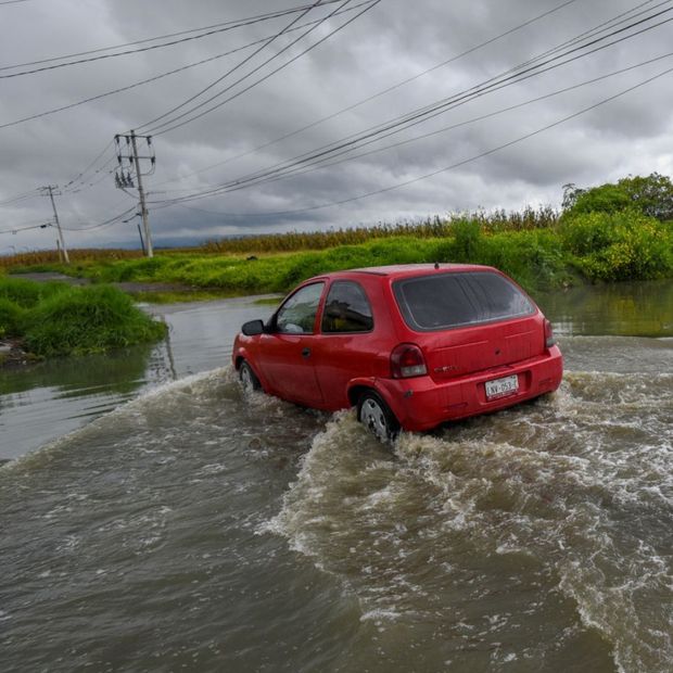 Un auto avanza en medio de una inundación en Calimaya, Estado de México