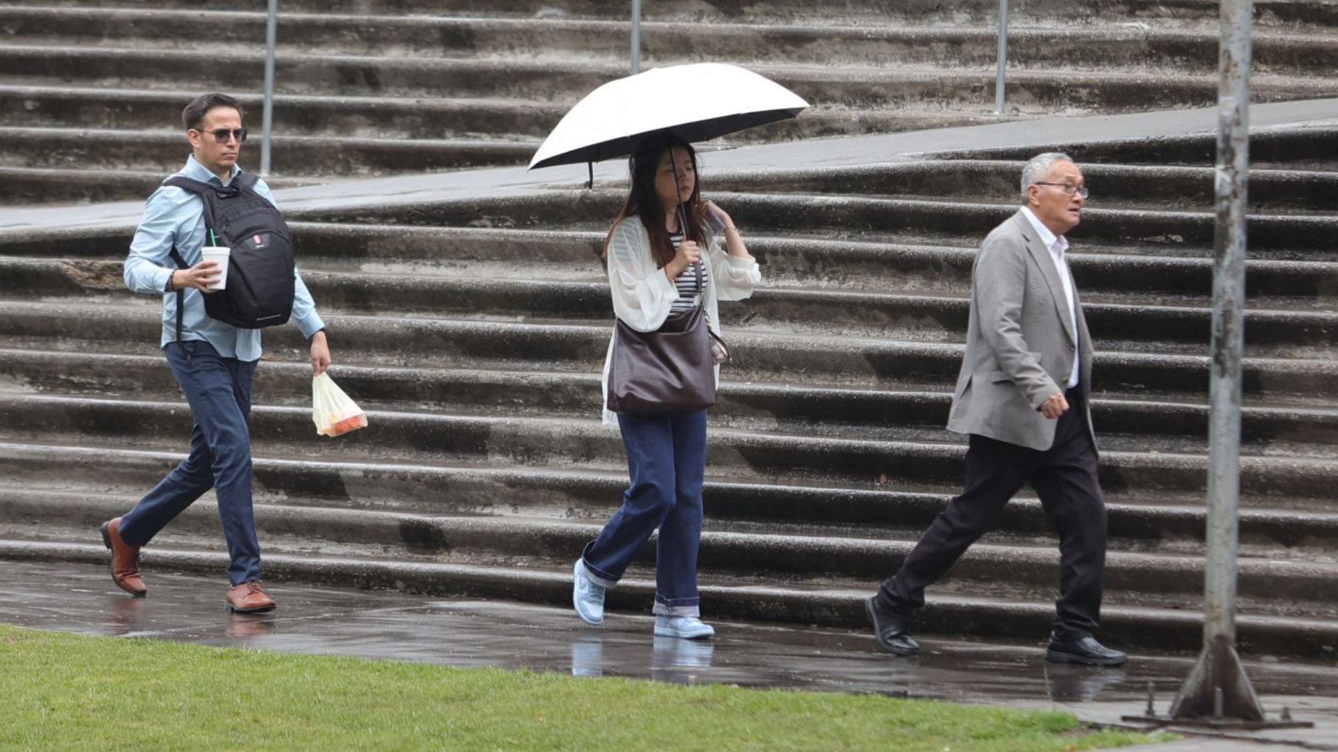 Tres personas caminan bajo la lluvia en CDMX