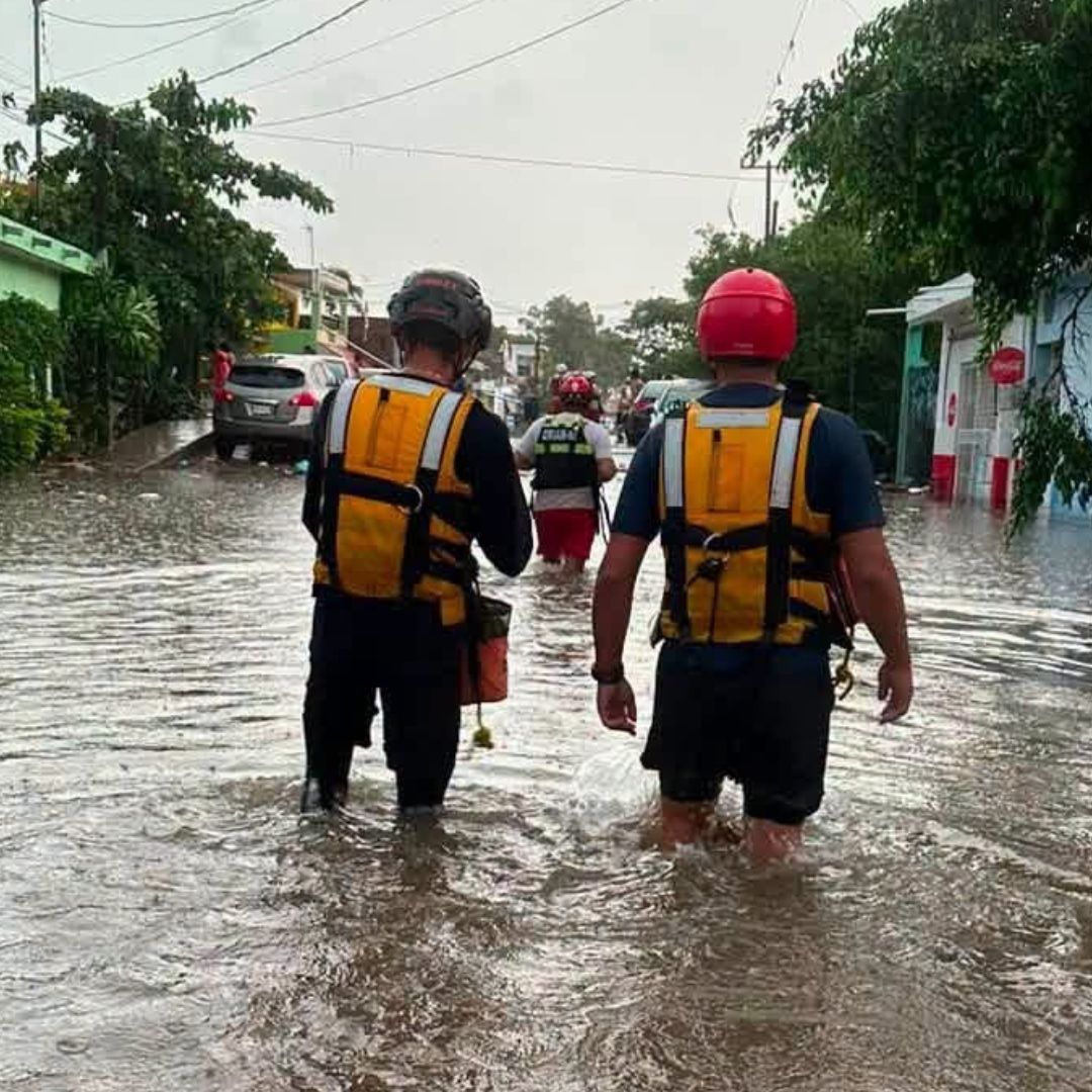 Elementos de Protección Civil de Mazatlán caminan por calles inundadas