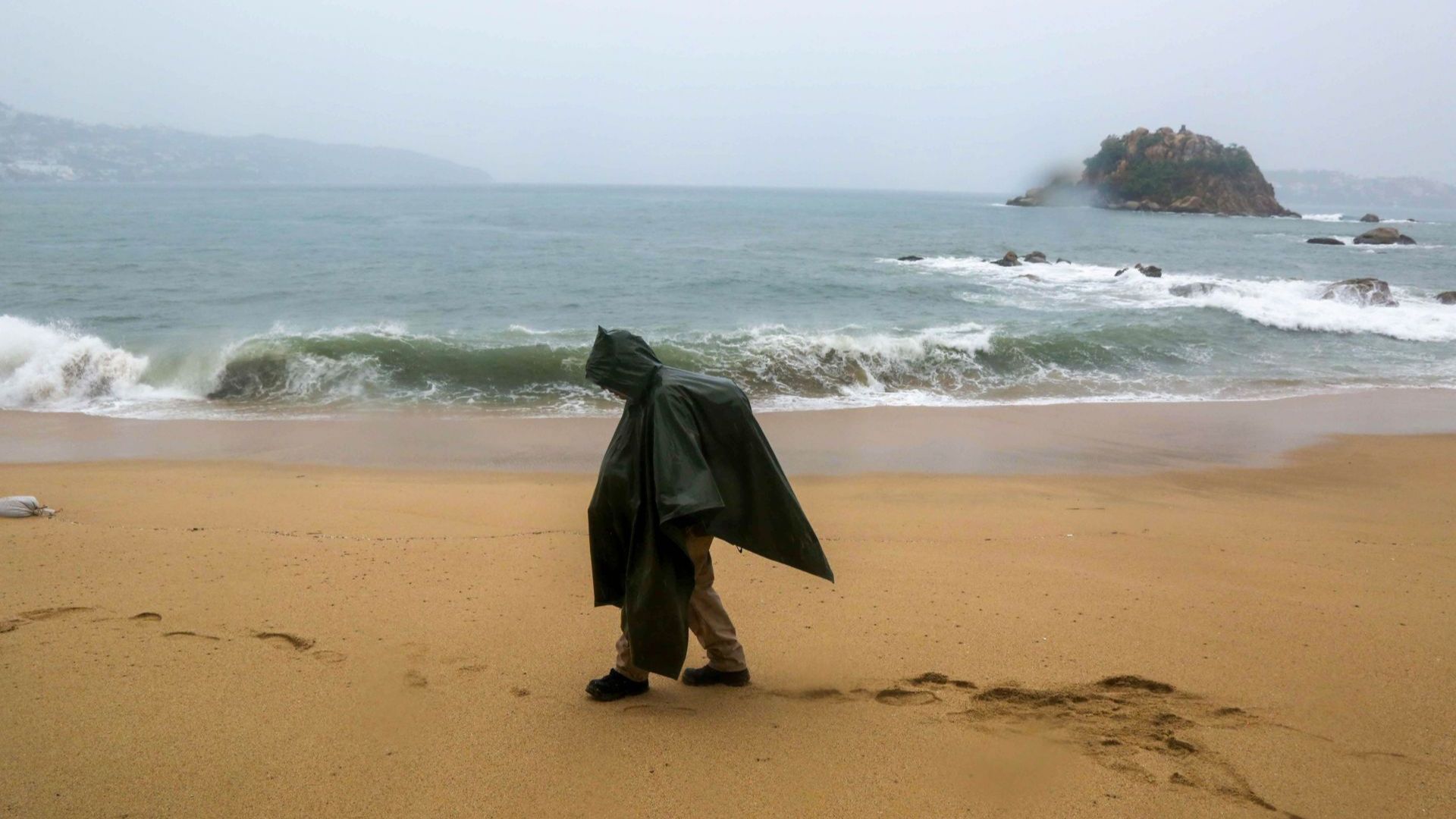 Un hombre camina sobre las playas de Acapulco