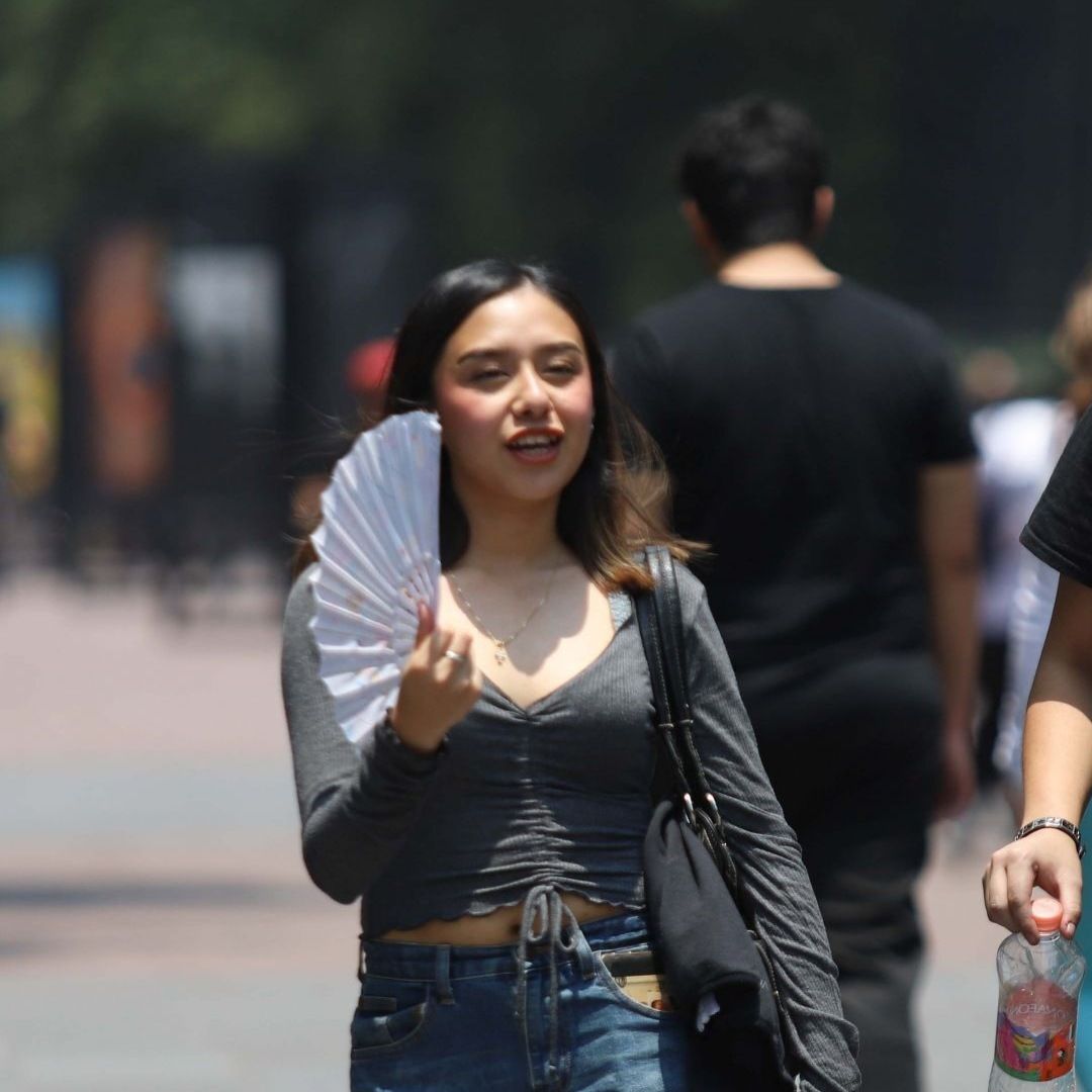 Una mujer y un hombre intentan contrarrestar el calor de la CDMX