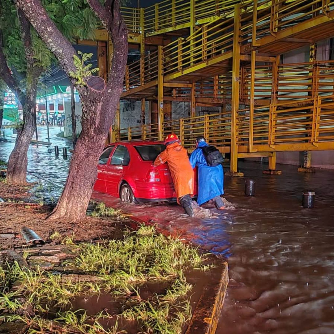 Elementos de Protección Civil de Michoacán ayudan a un conductor varado por las inundaciones en Morelia