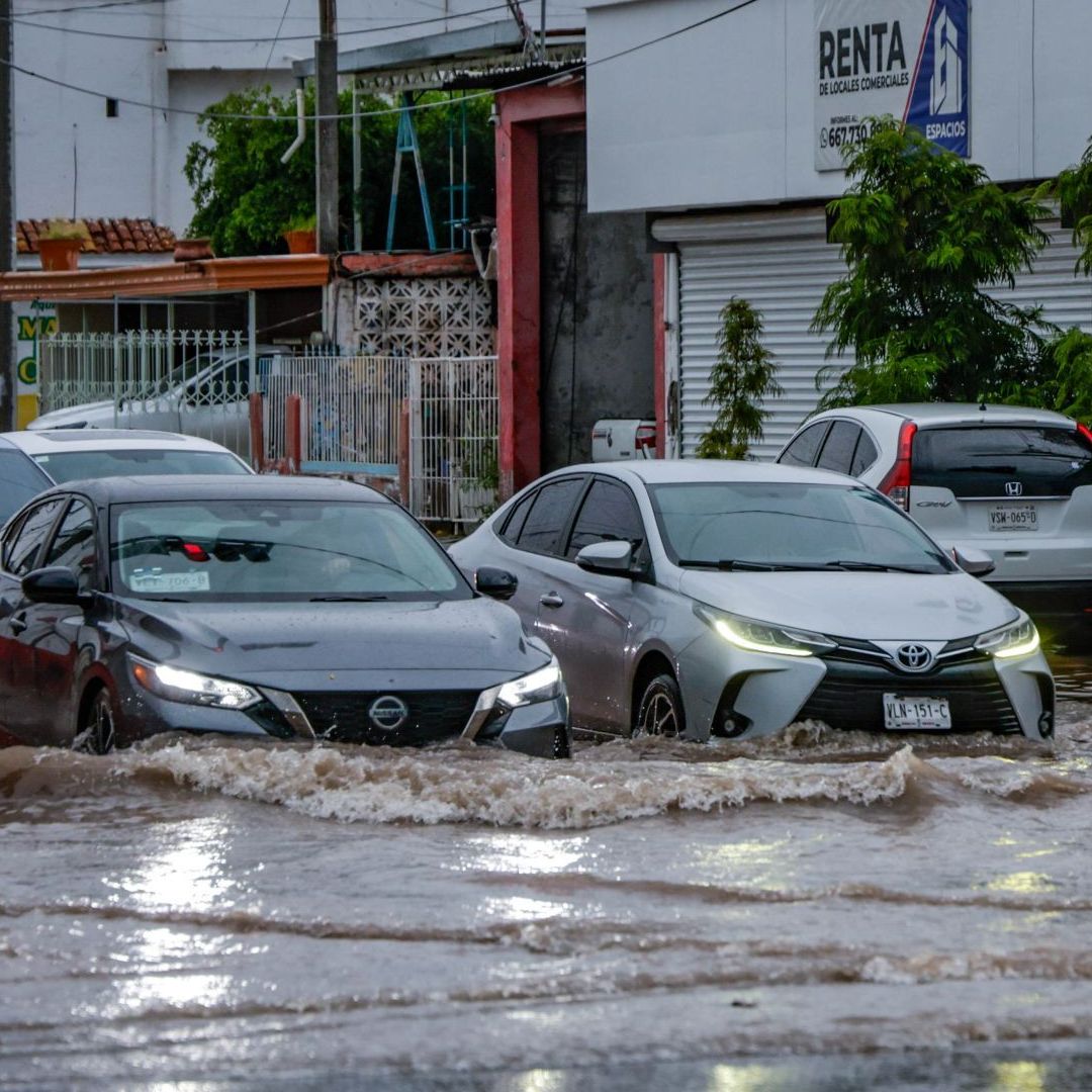 Autos cruzan una inundación en Culiacán, Sinaloa