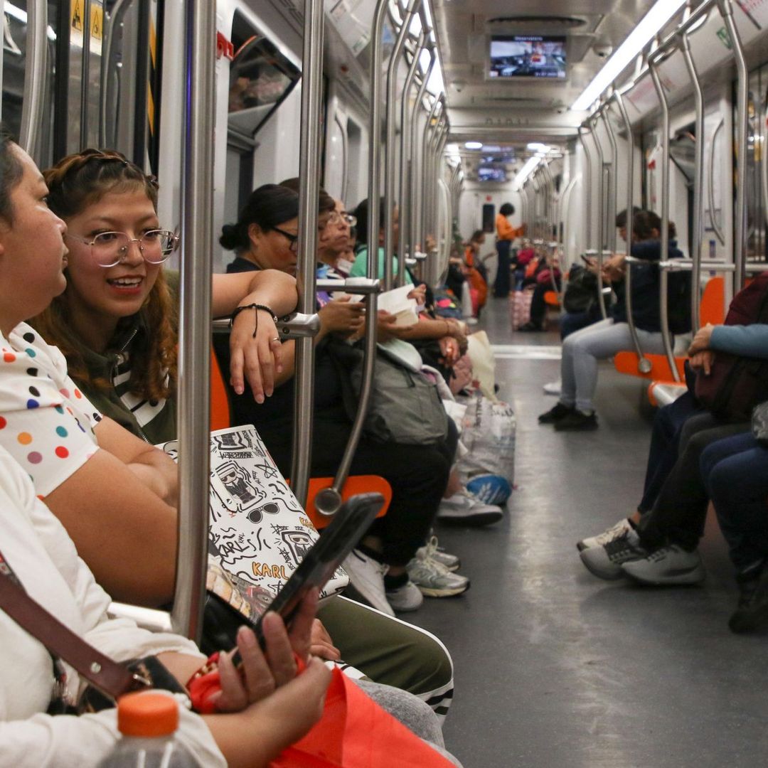 Personas revisan su teléfono celular dentro de vagón del Metro CDMX.