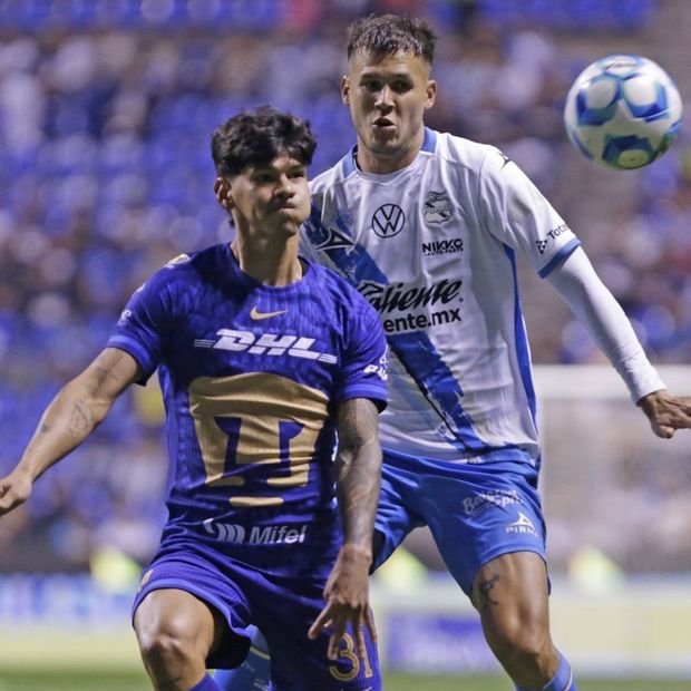 Robert Morales, delantero de Pumas, disputa un balón con el defensa poblano Juan Pablo Vargas en el Estadio Cuauhtémoc.