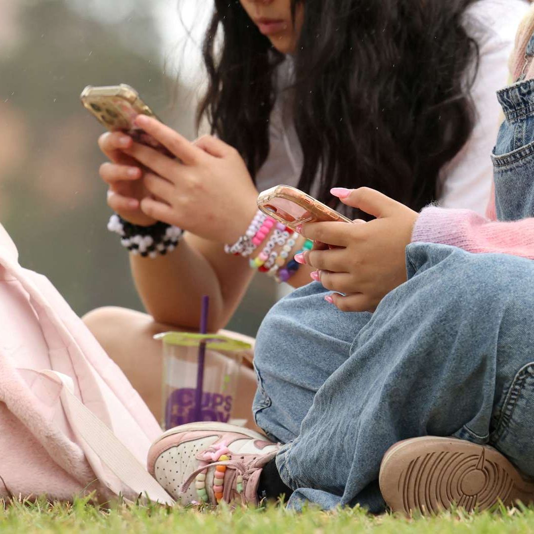 Dos adolescentes usan sus teléfonos luego de la prohibición de redes sociales para menores en Australia. Foto: Reuters | Archivo
