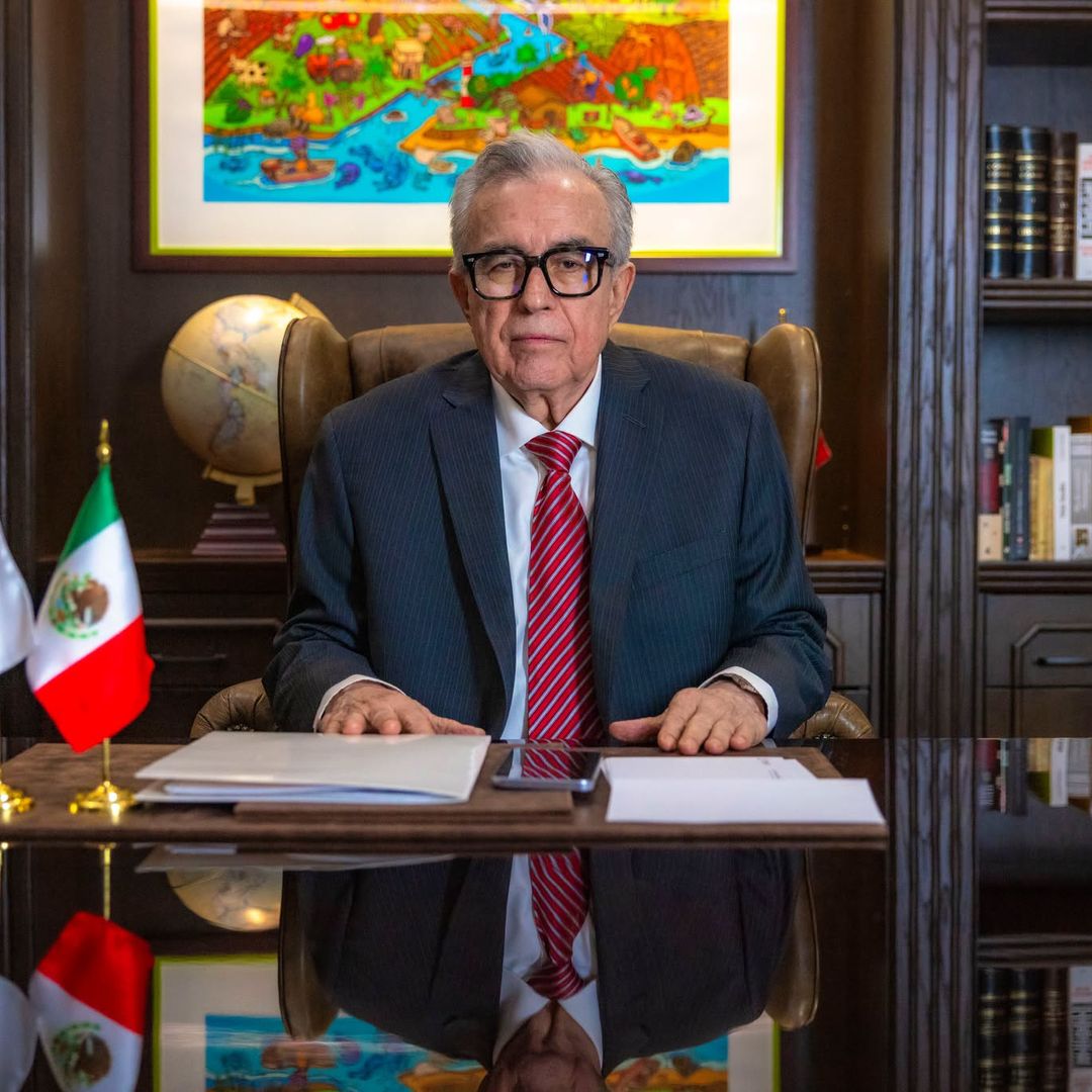 Rubén Rocha Moya sentado detrás de escritorio, vistiendo traje y corbata